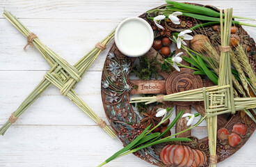 Wiccan altar for Imbolc sabbat. witchcraft, magic ritual. wheel of the year with Brigid's cross,...