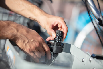 a man clamps a bicycle lock - hands close-up