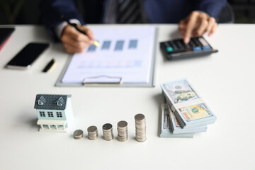 Investing in Real Estate, Real estate agent or investor calculating, planning, analyzing financial data for property investment. Themes of saving, investing, financial aspects of purchasing a home.