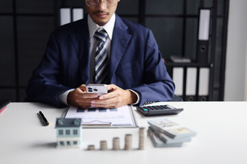 Investing in Real Estate, Real estate agent or investor calculating, planning, analyzing financial data for property investment. Themes of saving, investing, financial aspects of purchasing a home.