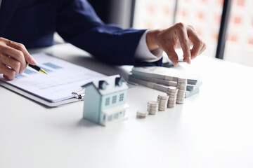 Investing in Real Estate, Real estate agent or investor calculating, planning, analyzing financial data for property investment. Themes of saving, investing, financial aspects of purchasing a home.