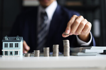 Investing in Real Estate, Real estate agent or investor calculating, planning, analyzing financial data for property investment. Themes of saving, investing, financial aspects of purchasing a home.