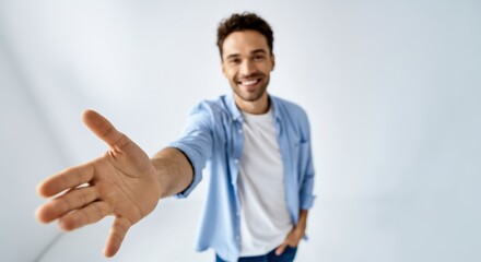 Man offering handshake and smiling in bright minimal studio with open space