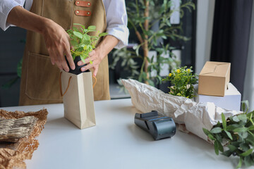 A small business, a florist or a gift shop worker preparing a customer's order.