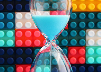 Hourglass with colorful puzzle pieces in the background
