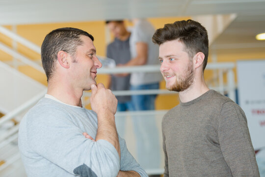 two men are talking in the corridor