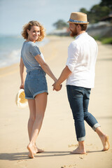 couple walking on the beach on a sunny day
