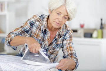 senior woman close up ironing clothes