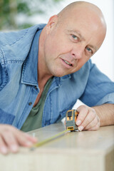 senior man takes measures for furniture