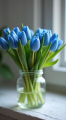 Vase with blue flowers in it on a window sill