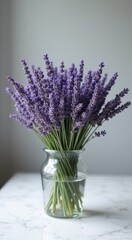 Lavender flowers in a glass vase on a marble table