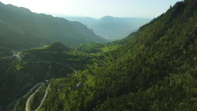 aerial footage capturing the stunning natural beauty of the Zalala Ridge in Dagestan, Russia. The drone shot showcases the dramatic mountain landscape, covered in lush green forests, and a winding roa