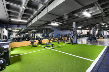 A modern gym filled with energy, featuring strength machines, free weights, and cardio equipment. Bright lights, mirrors, and focused people create a motivating space for fitness and strength.

