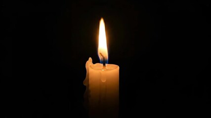 Candle flame flickering in darkness demonstrating gentle movement and light variations