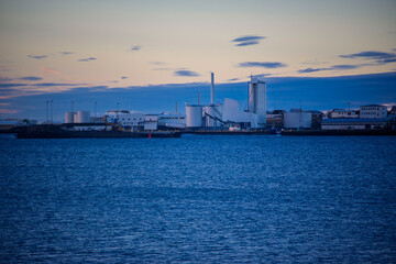 Obraz premium Industrial harbor with factory buildings and calm sea at dusk in Akranes, Iceland
