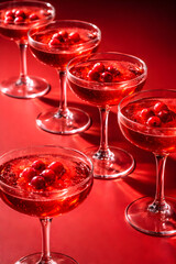 Cranberry cocktails in martini glasses on red background