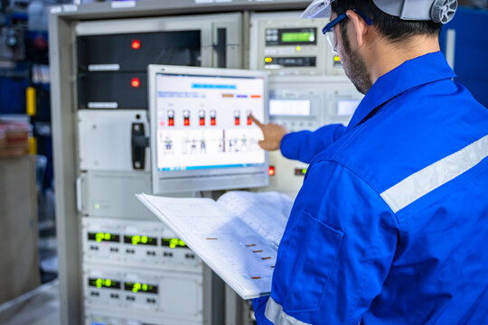 Electrical engineer male checking voltage at the Power Distribution Cabinet in the control room,preventive maintenance Yearly,inspecting power system and control panel in industrial factory
