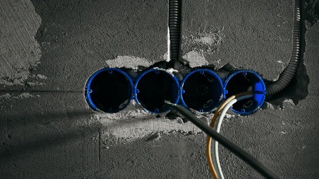 Unfinished Interior Electrical Junction Boxes Emerge From Concrete Surfaces With Exposed Wiring