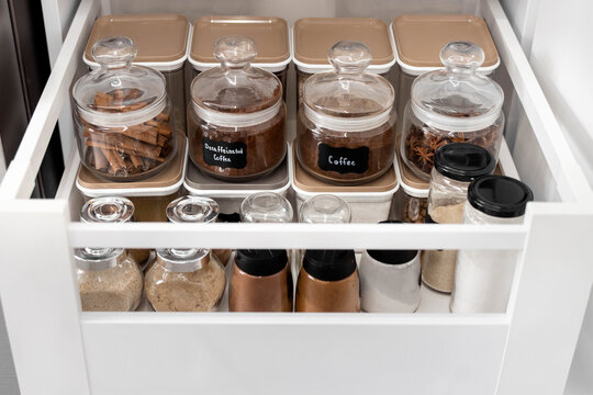 Close-up of jars of spices standing in a kitchen drawer. Storing spices in the kitchen. Home routine. Horizontal photo