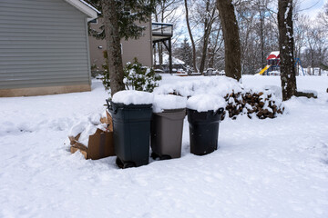 trash cans and woodpile covered with snow in winter