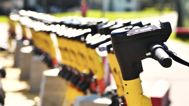Row of yellow electric scooters parked in a line, providing eco-friendly city transportation