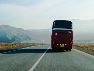 Red bus is driving down a road