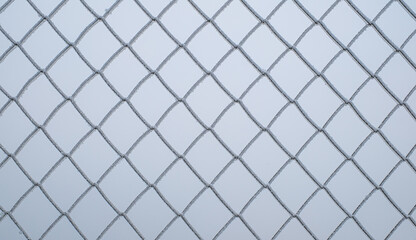 Fototapeta premium a chain-link fence covered in ice crystals on a cold winter day