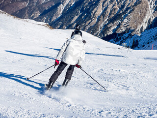Skier is skiing down a snowy slope