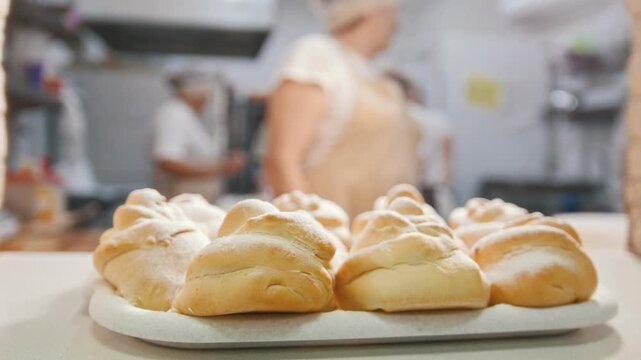 Cook put the fresh hot pastries in the bakery