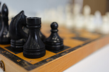 Intricate chess pieces poised on a wooden board ready for a strategic battle