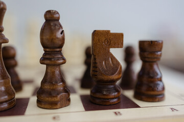 Intricate wooden chess pieces poised for a strategic battle on the board