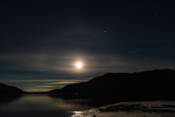 Fototapeta premium A view of the Moon casting a Moonbow over Ullswater in the English Lake District