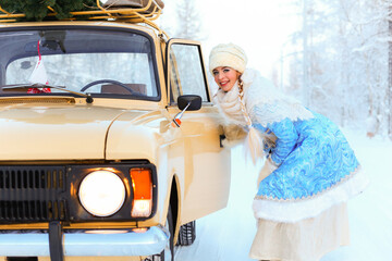 Snegurochka looking in the mirror of the yellow retro car