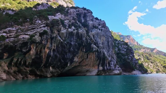 Boat trip on turquoise water of mountain canyon, Verdon Gorge in french Alps, Provence France. Near Aiguines. Canyon is about 25 kilometres long and up to 700 metres deep.