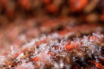 Snowflake. Macro.  A small snowflake on a knitted scarf.