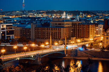 City River With Glowing Bridges, Nighttime Scene Of Vltava With Vibrant Reflections On Tranquil Water