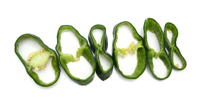 Stack dark green poblano peppers isolated on white