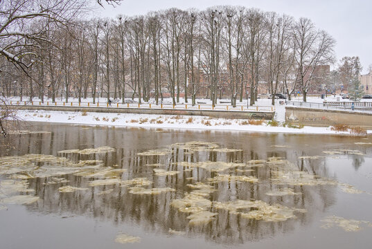  Park covered in snow with bare trees along frozen Emajogi river on a cold winter dya in Tartu, Estonia 