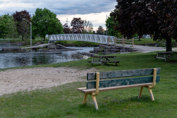 Scenic park with pedestrian bridge and picnic tables in Smiths Falls, Ontario, Canada.