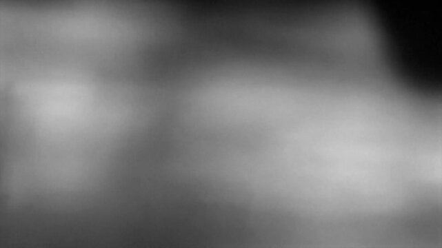Blurred light leaks, defocused bokeh lights reflect on the surface. Abstract monochrome video with noise and grain effect