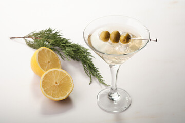 Dry Martini Served With Lemon and Olive on a Simple White Table