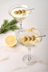 Dry Martini Served in Glasses With Olives and Lemon on a Table