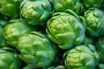 Obraz premium Fresh green artichokes tightly grouped together, showcasing their vibrant color and unique texture, perfect for culinary and healthy lifestyle concepts