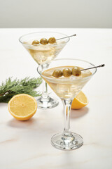 Dry Martini Served in Glasses With Olives and Lemon on a Table