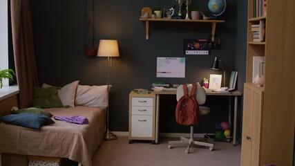 Full no people shot of cozy kids room interior with organized study space near comfortable bed, schedule on wall and trophies for academic achievement on shelf