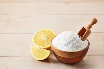 Wooden bowl of baking soda powder and lemons