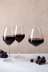 Three glasses of red whine and fresh grapes