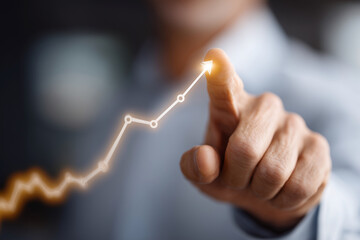 A man is pointing at a graph with a line that is rising