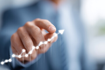 A man is pointing to a graph with a rising arrow