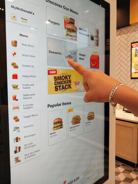 December 5, 2025 - Sharjah, United Arab Emirates: Woman ordering McDonald's fast food a self-order machine. Close up shot of self-ordering kiosk.